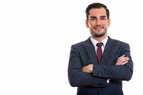 Studio shot of happy young handsome businessman smiling with arm - Photo, Image