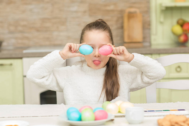 Funny little girl with two Easter eggs - Fotoğraf, Görsel