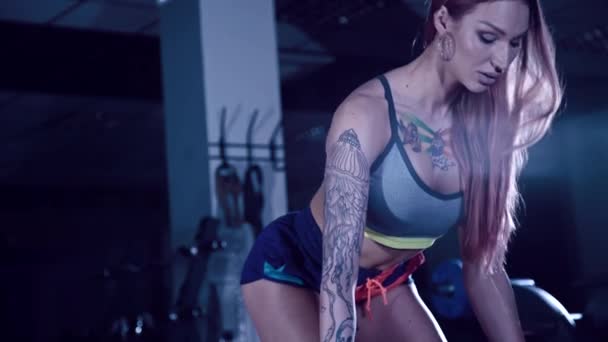 atletische meisje met tatoeages maken oefening met een barbell - Video