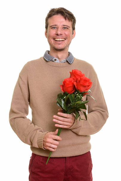 Szczęśliwy kaukaski mężczyzna trzyma czerwone róże gotowy na Walentynki - Zdjęcie, obraz