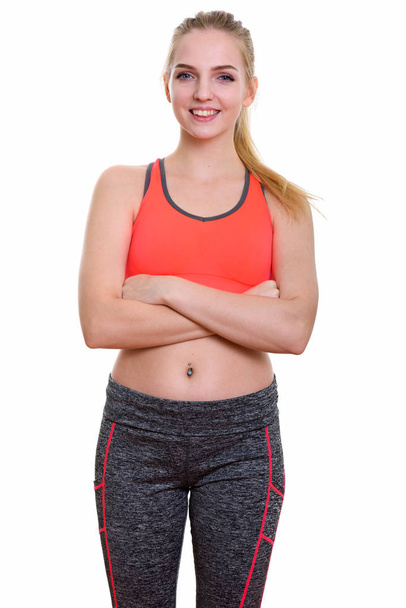 Studio shot of young happy teenage girl smiling with arms crosse - Photo, image