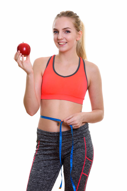 Young happy teenage girl smiling while holding red apple and mea - Foto, afbeelding