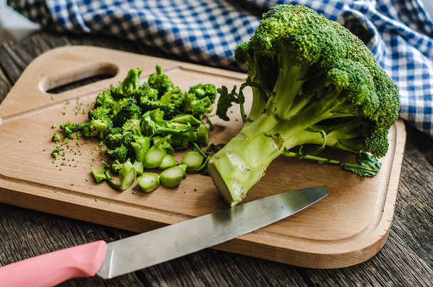 Fresh broccoli on wooden table, on a cutting board - Foto, afbeelding