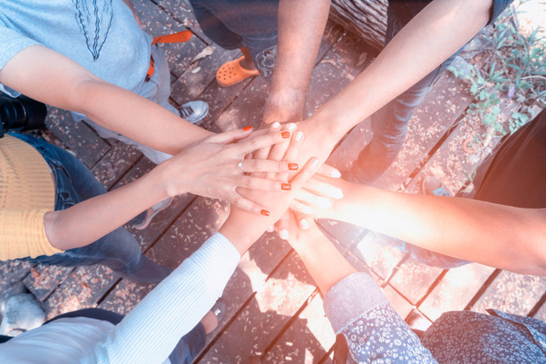 Business teamwork hands together joining group of people in circle with sun ray light and lens flare. - Concepts collaborate team and projects process to success. - Photo, Image