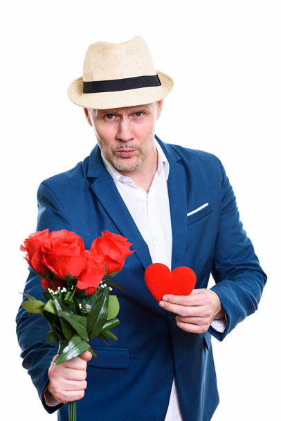 Mature businessman giving red roses and holding red heart ready  - Foto, Imagen