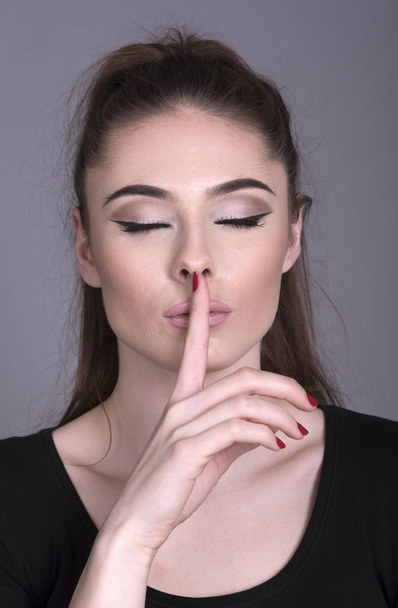 Femme tenant son index sur ses lèvres
 - Photo, image
