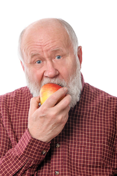 Cheerfull senior man eating the apple, isolated on white - Photo, Image