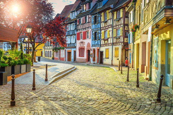 Coloridas fachadas medievales de entramado de madera con camino pavimentado en Colmar
 - Foto, imagen