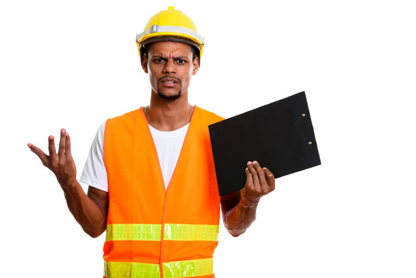 Jovem irritado homem africano trabalhador de construção segurando prancheta wi
 - Foto, Imagem