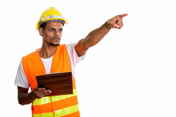 Young African man construction worker holding clipboard while po - Foto, immagini