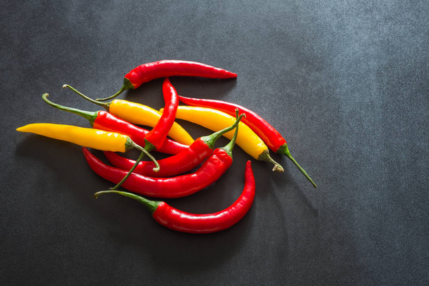 Colorful hot paprika on a stone dark table - Foto, afbeelding