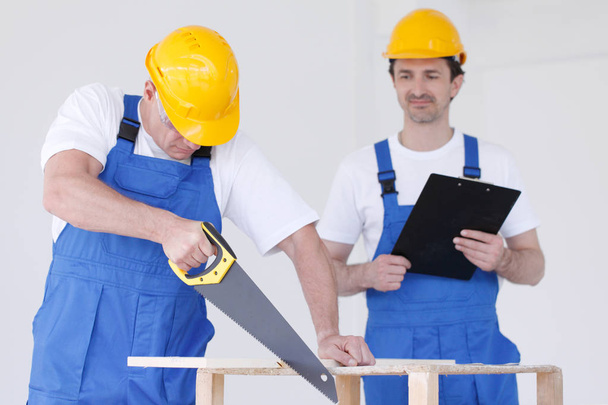 Two workmen with saw and folder - Photo, Image
