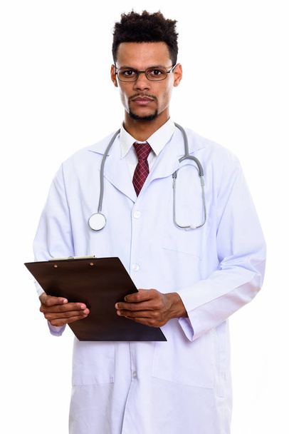 Studio shot of young African man doctor holding clipboard - Photo, Image