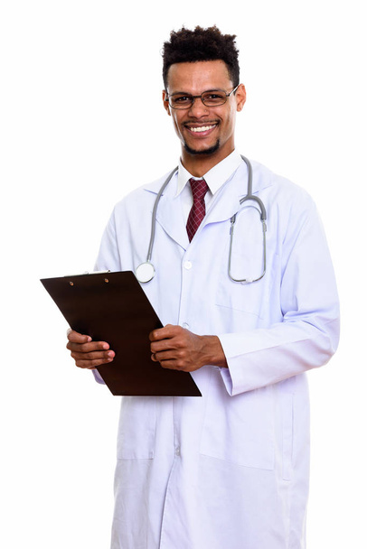 Молодой счастливый африканский врач улыбается, держа планшет. - Фото, изображение