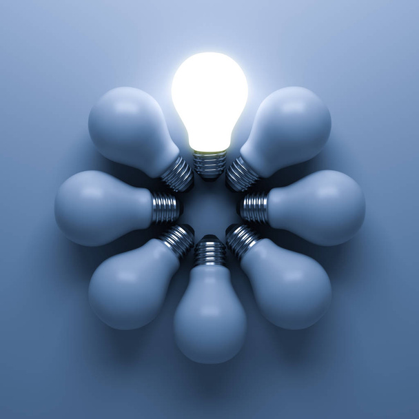 Une ampoule lumineuse se détachant des ampoules incandescentes non éclairées sur fond bleu avec ombre, individualité et différents concepts d'idées commerciales créatives
 - Photo, image