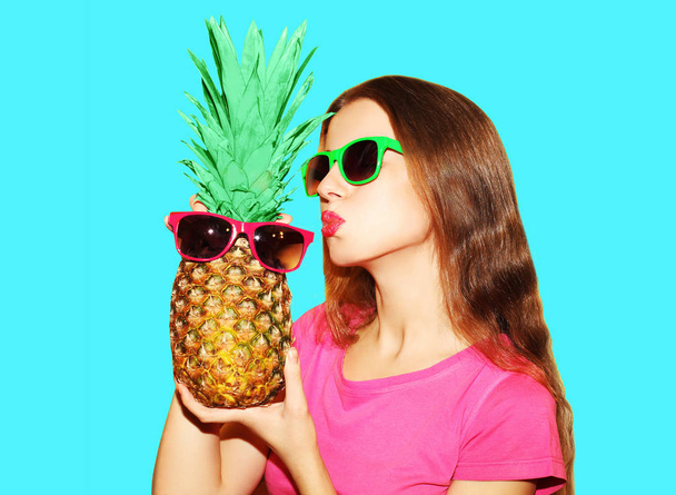 Fashion portrait pretty woman and pineapple in sunglasses over b - Foto, Imagen