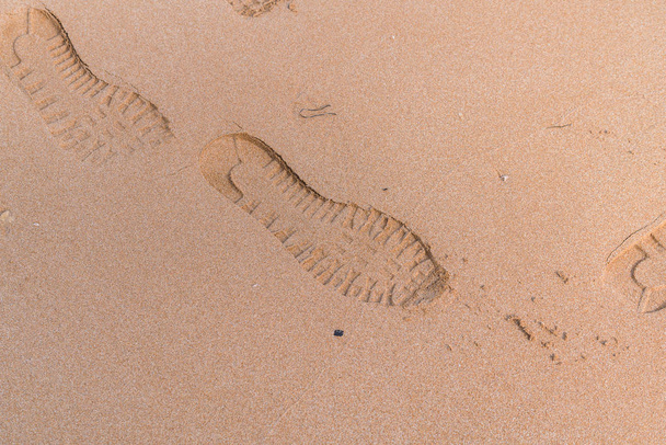 Pegadas na areia perto das ondas
 - Foto, Imagem
