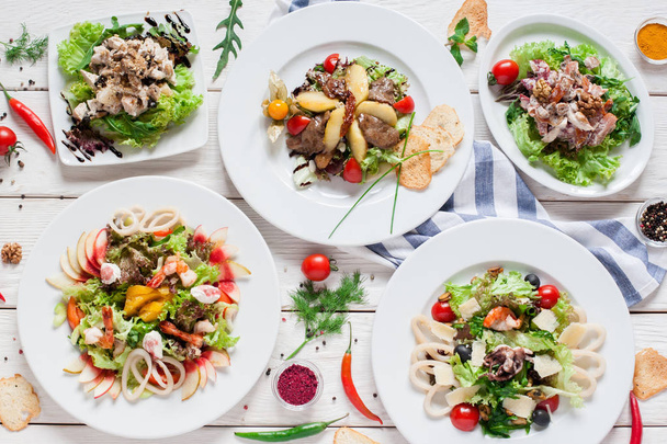 Warm salads assortment on restaurant table - Foto, afbeelding