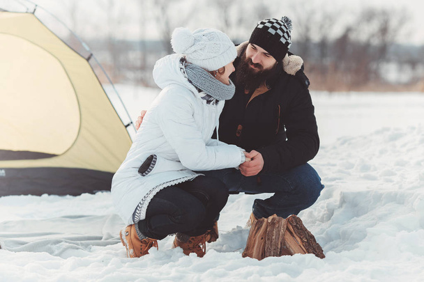 Couple hold hands near firewood over camping tent - Φωτογραφία, εικόνα