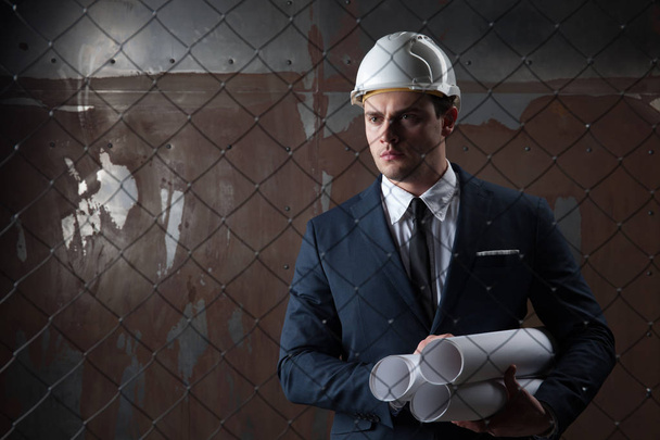 Portrait d'un architecte en concept industriel en casque blanc sur fond sombre
 - Photo, image