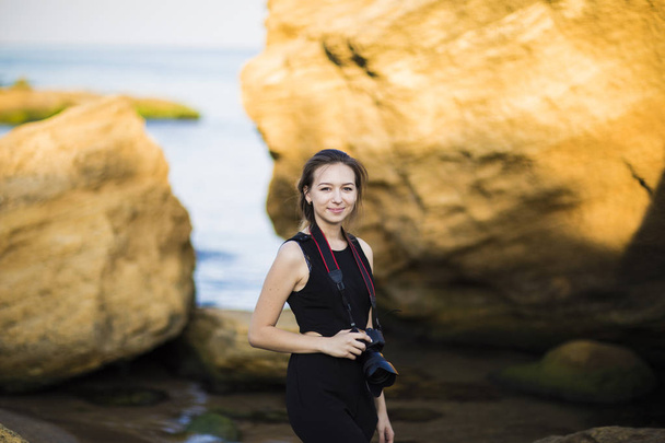 Retrato de bela jovem fotógrafa turística com câmera no mar
 - Foto, Imagem