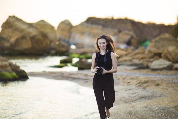 Retrato de hermosa joven fotógrafa turística con cámara en el mar
 - Foto, Imagen