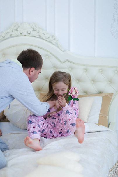 Ο μπαμπάς κόρη γαργαλήματα, έπαιξε με το κορίτσι στο κρεβάτι στο σπίτι - Φωτογραφία, εικόνα