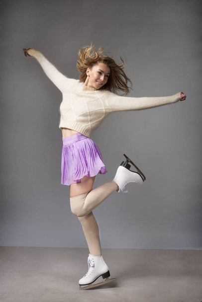 Young funny girl in a skirt skates on ice - Foto, afbeelding