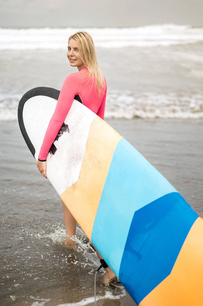 Girl with surfboard on beach - Photo, image