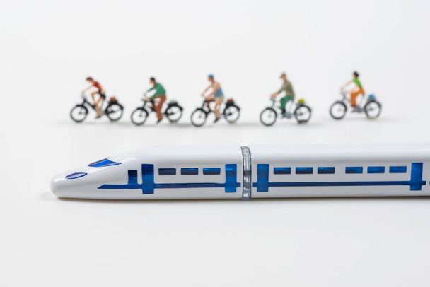 high speed train model and miniature people riding a bike - Photo, Image