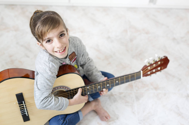 9-jähriges Mädchen lernt Gitarre spielen.  - Foto, Bild