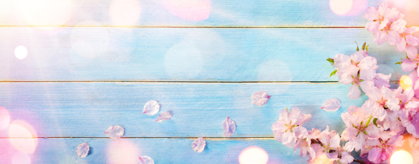 Цветок миндаля на голубом деревянном столе
 - Фото, изображение