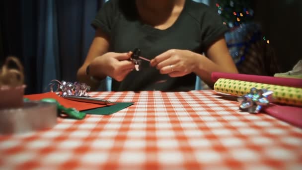 Θηλυκό κατσαρώνει την κορδέλα, προετοιμασία για τη συσκευασία παρουσιάζει - Πλάνα, βίντεο