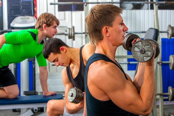 Fitness men friends in gym workout weights with equipment. - Φωτογραφία, εικόνα