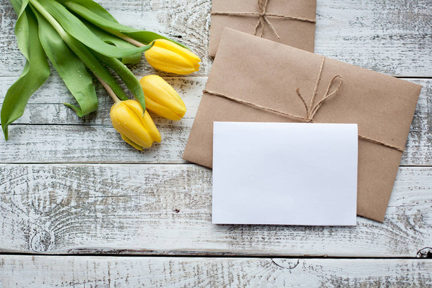 жовтий букет тюльпанів і чиста вітальна листівка. Вид зверху над дерев'яним столом
 - Фото, зображення
