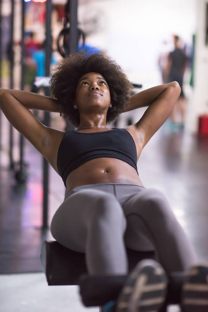 black woman doing sit ups at the gym - 写真・画像