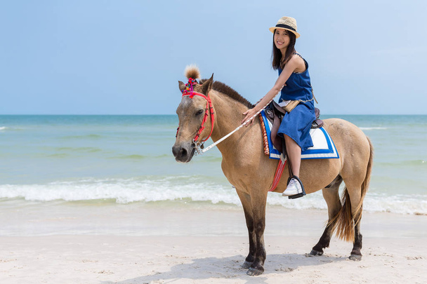 Mujer cabalgando a caballo en playa de arena
 - Foto, Imagen