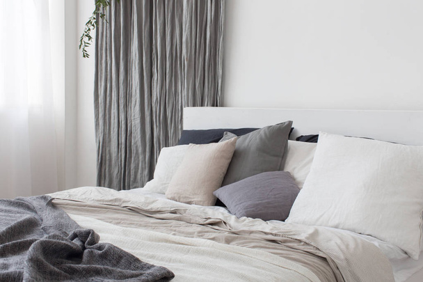 Bett mit weißer und grauer Bettwäsche - Foto, Bild