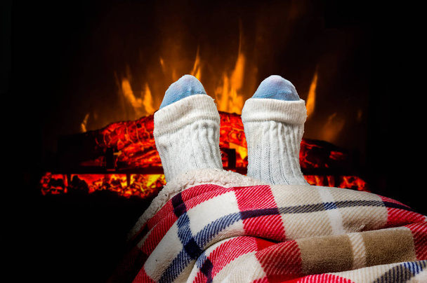 Woman warming feet in woolen socks near fireplace - Photo, Image
