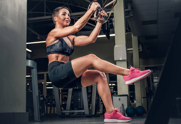 Female doing workouts with trx  strips - Photo, image