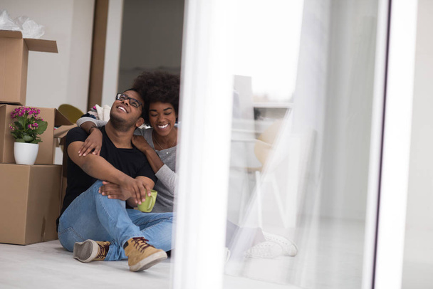 African American couple relaxing in new house - Фото, изображение
