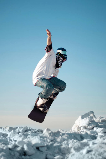 Snowboarder making jump against the clear blue sky - Photo, image