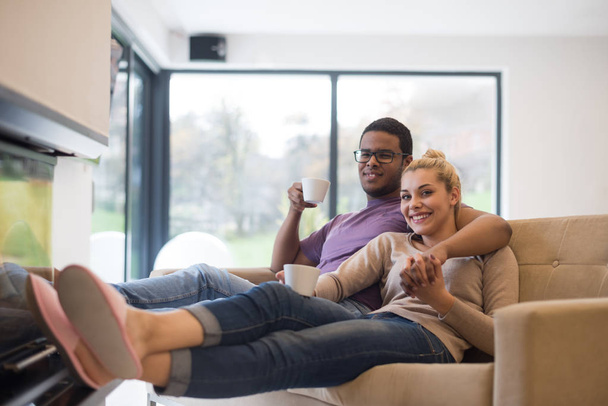 Young multiethnic couple in front of fireplace - Foto, Imagem