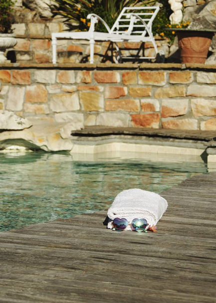 білий рушник і сонцезахисні окуляри форма серця на краю синього басейну, вибірковий фокус
 - Фото, зображення