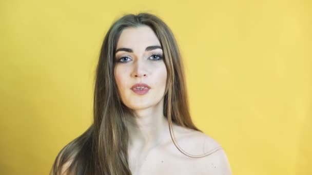 Portrait of the girl with joyful emotion on yellow background in 4K - Záběry, video