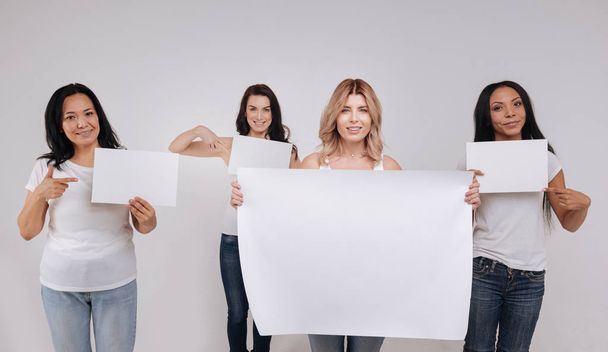 ladies demonstrating a big blank poster  - Foto, afbeelding