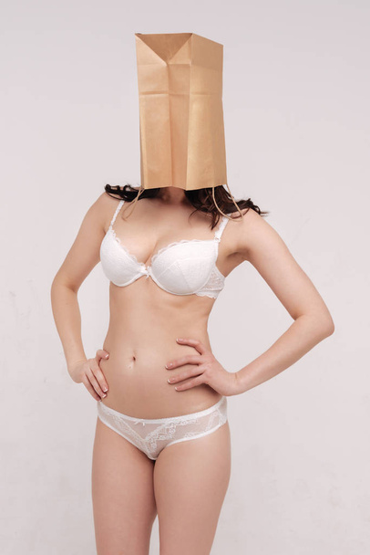 woman covering her face with a paper bag - Photo, image