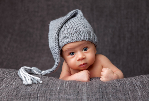 Beautiful newborn wearing a cute grey hat - Фото, изображение