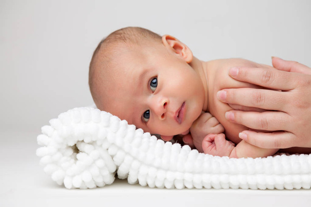 Милый новорожденный ребенок лежит на одеяле
 - Фото, изображение