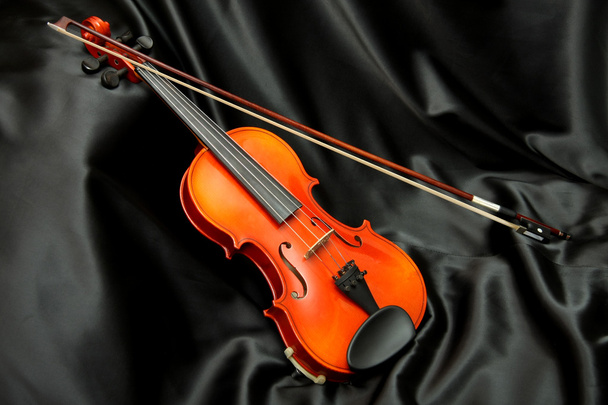 Violin and bow on black silk - Foto, afbeelding